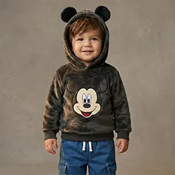 Kleinkind-Junge trägt einen Mickey-Mouse-Hoodie vor neutralem Hintergrund. Kleinkind-Junge trägt einen Mickey-Mouse-Hoodie vor neutralem Hintergrund.