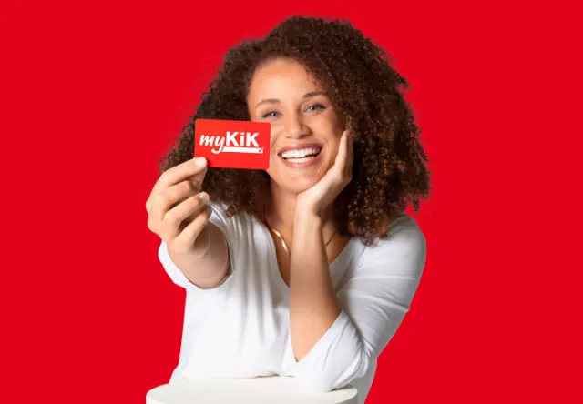 20% auf alle Versandkosten Eine Frau hält die myKiK-Vorteilskarte lächend in die Kamera