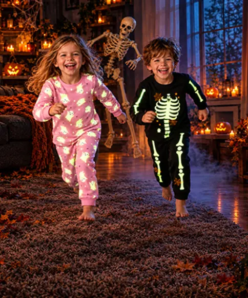 Kinder in Halloween-Pyjamas mit Geister- und Skelettmotiven